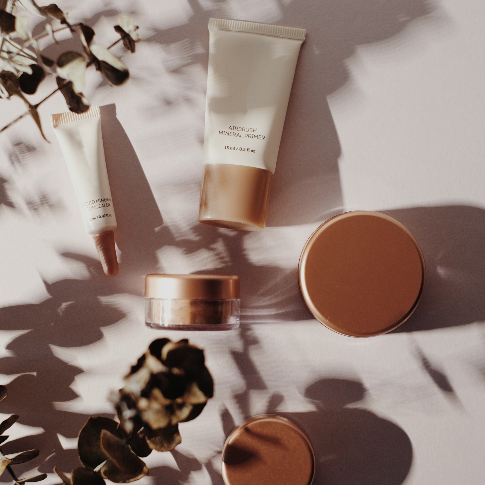 Skincare and makeup products sitting on top of a pink table